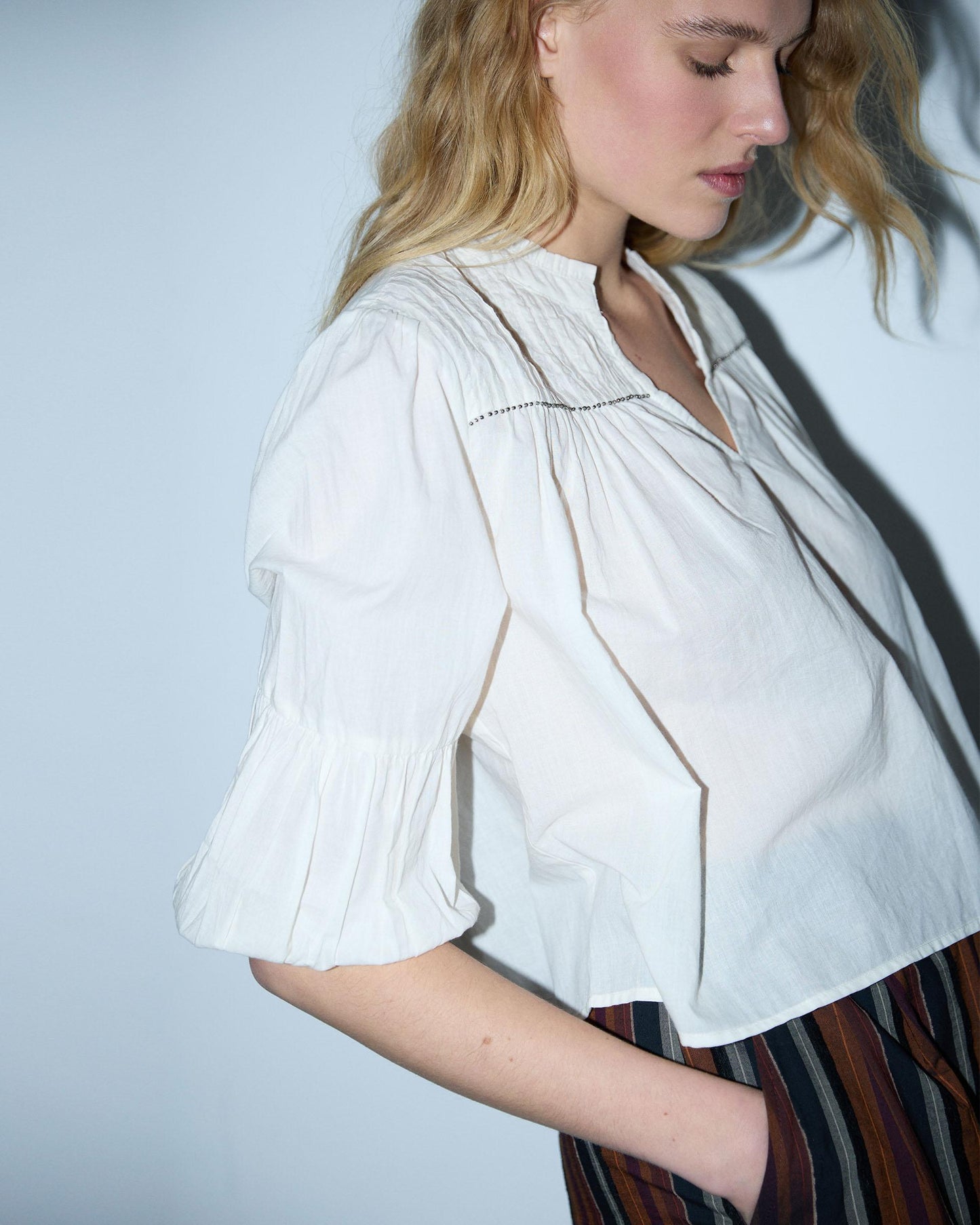 Blusa branca com cordões e missangas.