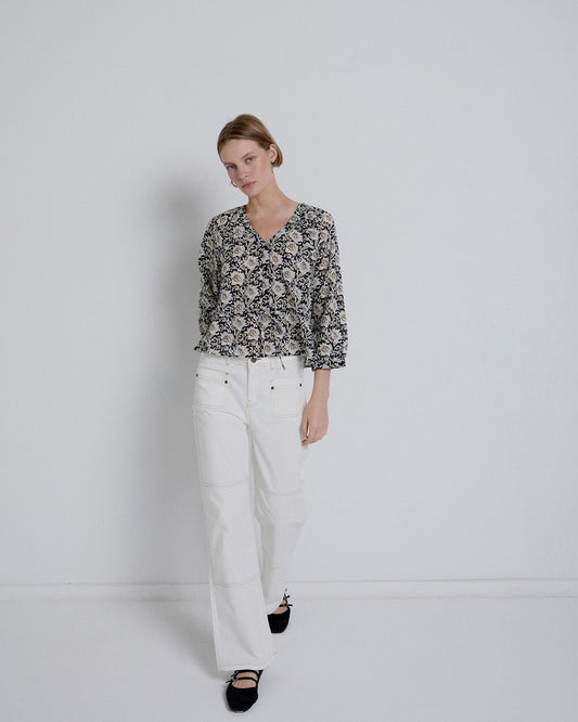 Blusa preta com estampado de flores e atilhos na cintura