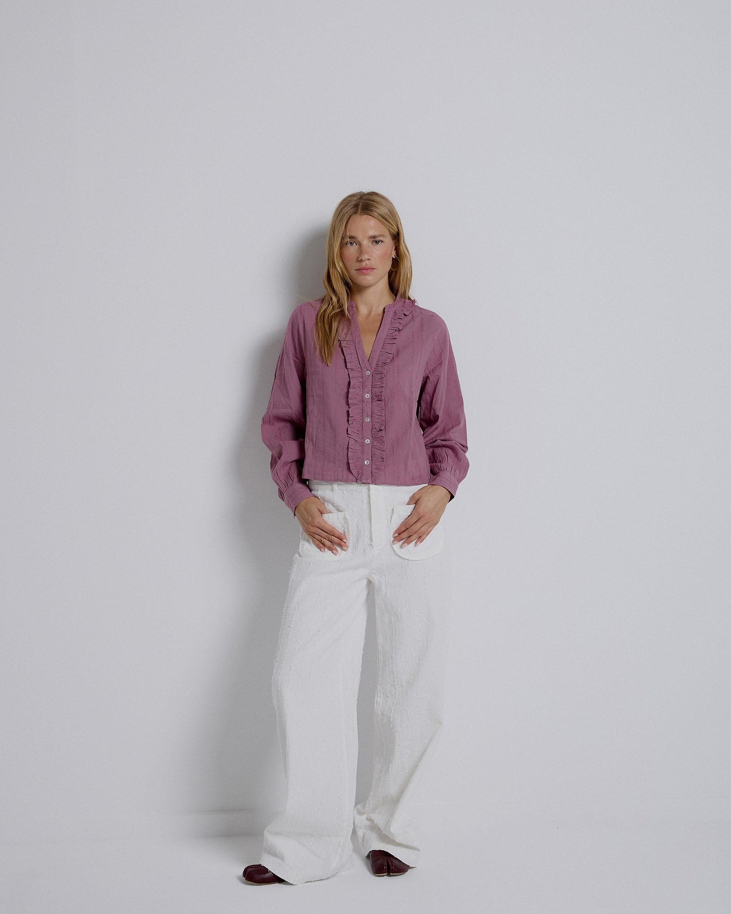 Blusa de tecido às riscas rosa com folhos