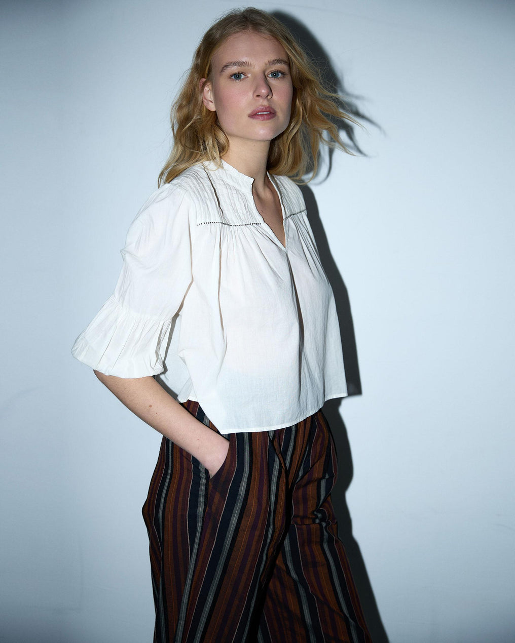 Blusa branca com cordões e missangas.