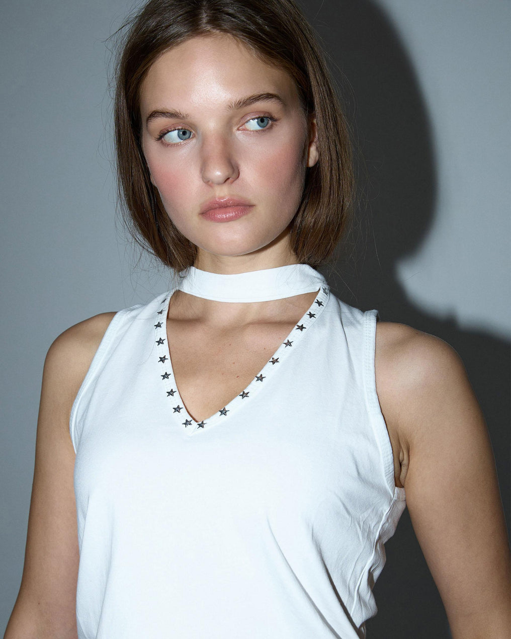 Camiseta branca com alça no pescoço e tachas