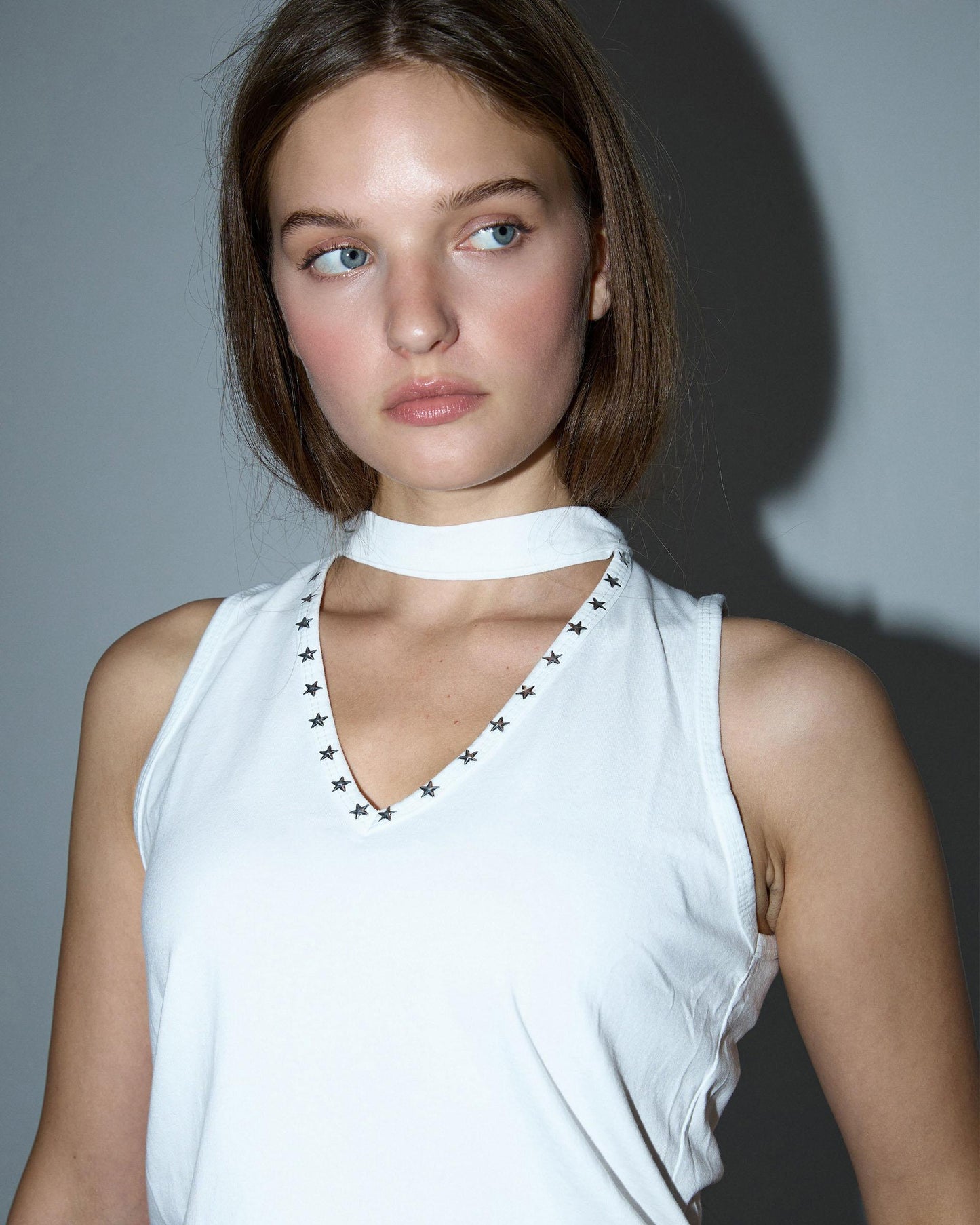 Camiseta branca com alça no pescoço e tachas