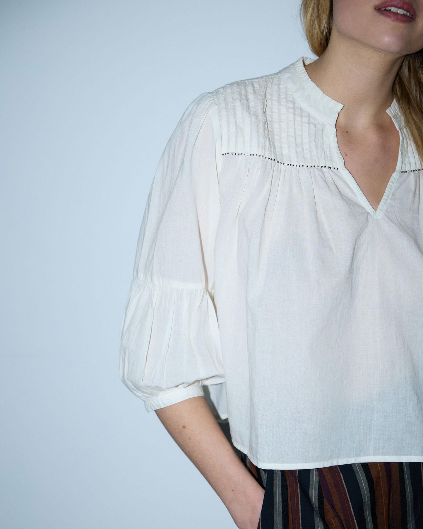 Blusa branca com cordões e missangas.