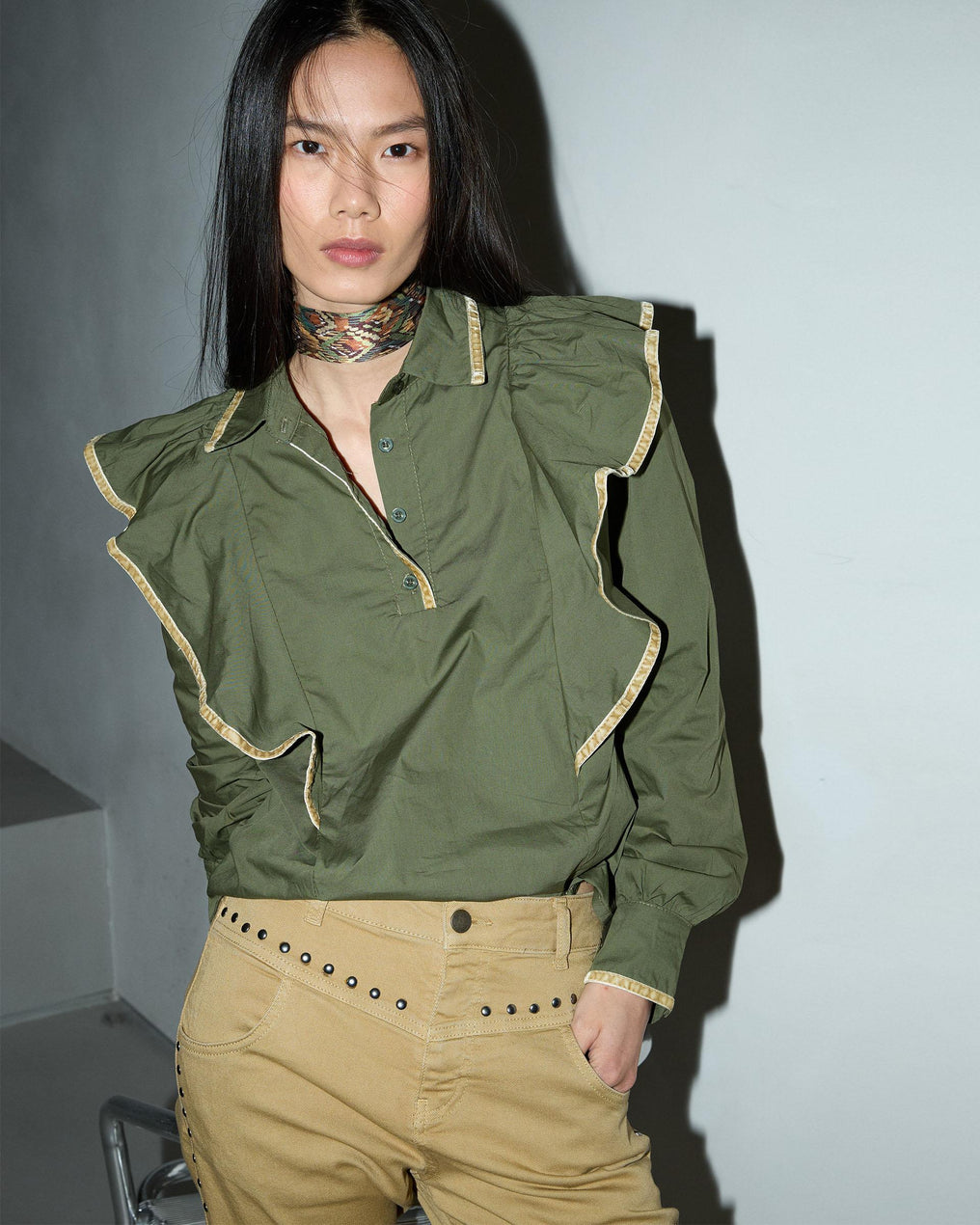 Blusa com detalhes verdes e folhos.