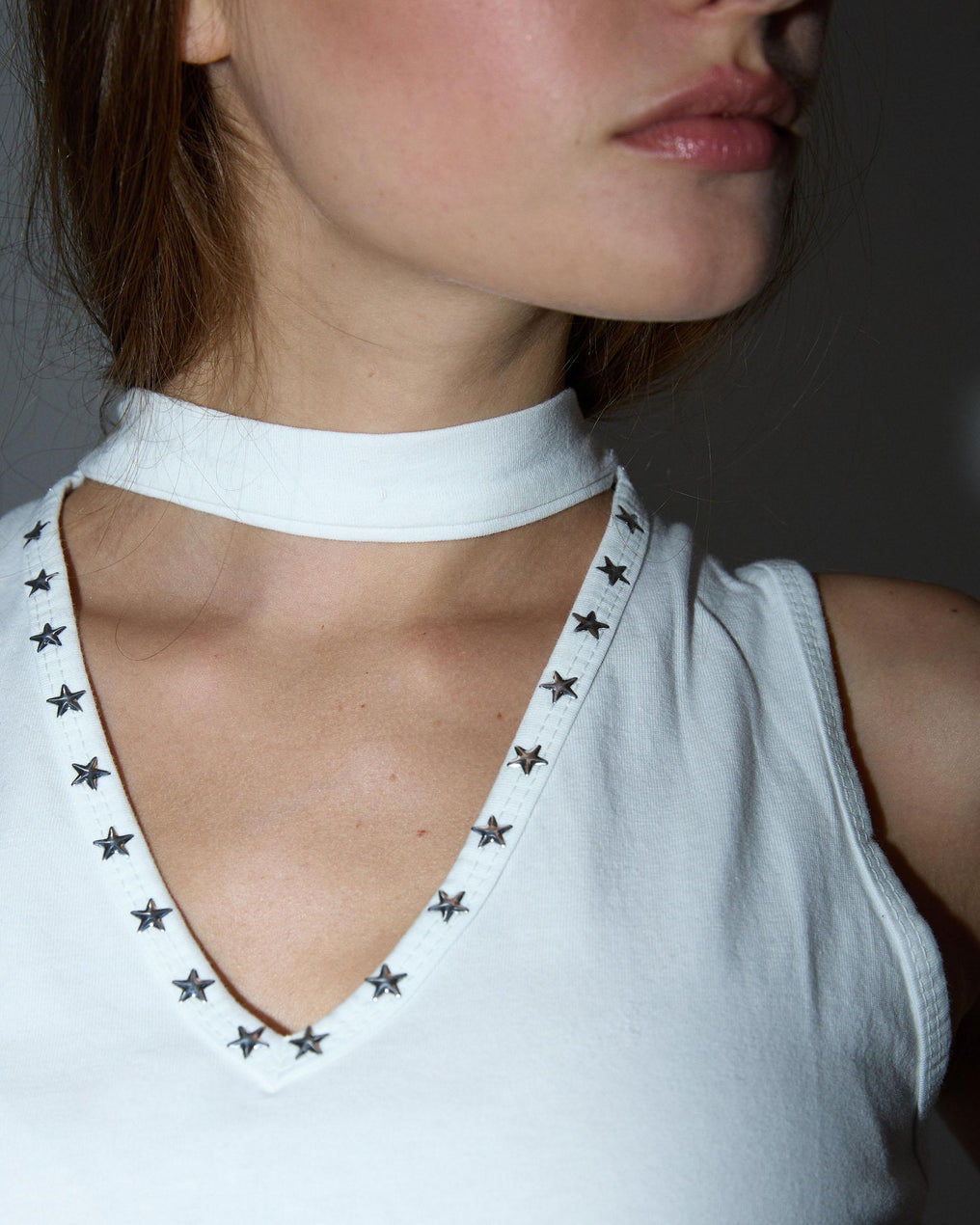 Camiseta branca com alça no pescoço e tachas