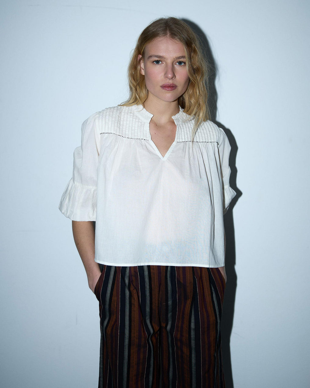 Blusa branca com cordões e missangas.