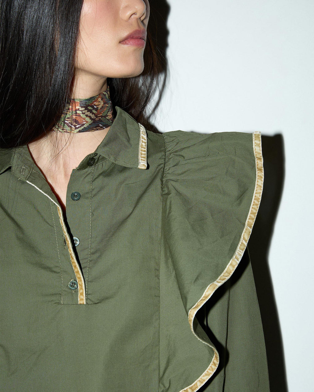 Blusa com detalhes verdes e folhos.