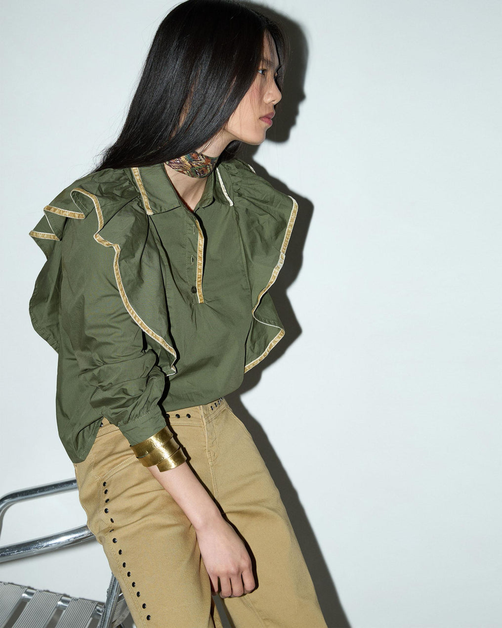 Blusa com detalhes verdes e folhos.