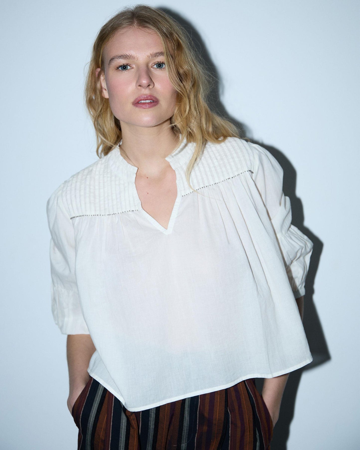 Blusa branca com cordões e missangas.