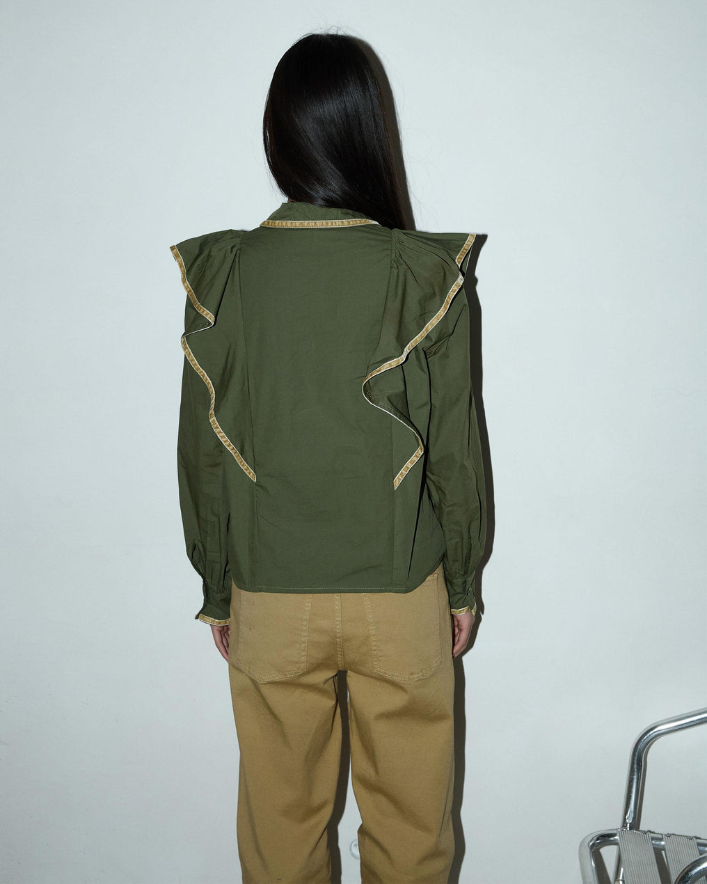 Blusa com detalhes verdes e folhos.