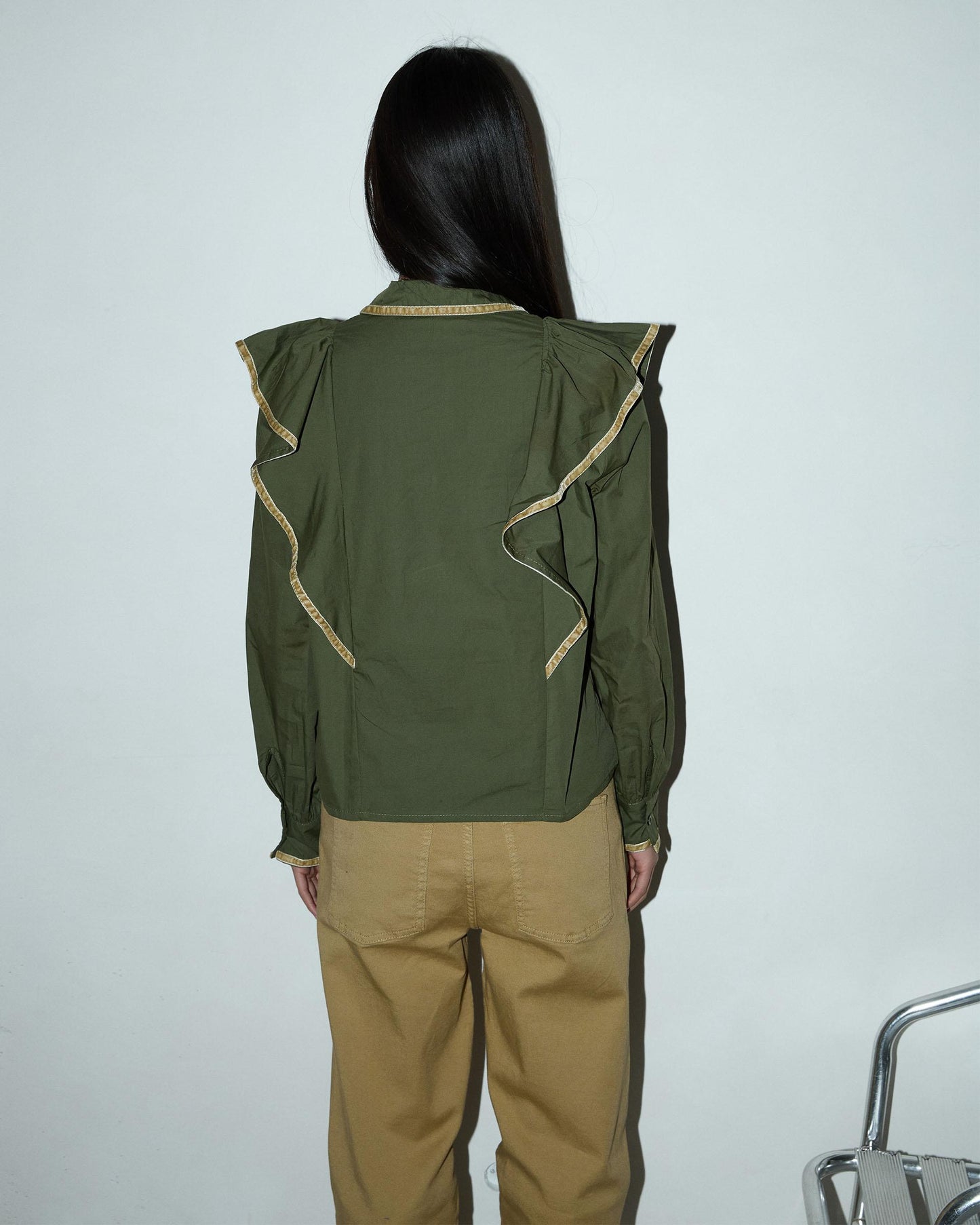 Blusa com detalhes verdes e folhos.