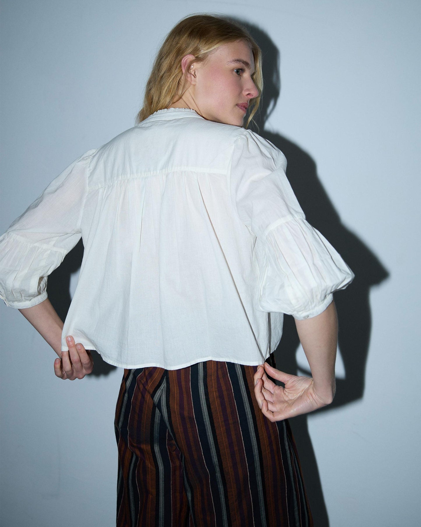 Blusa branca com cordões e missangas.