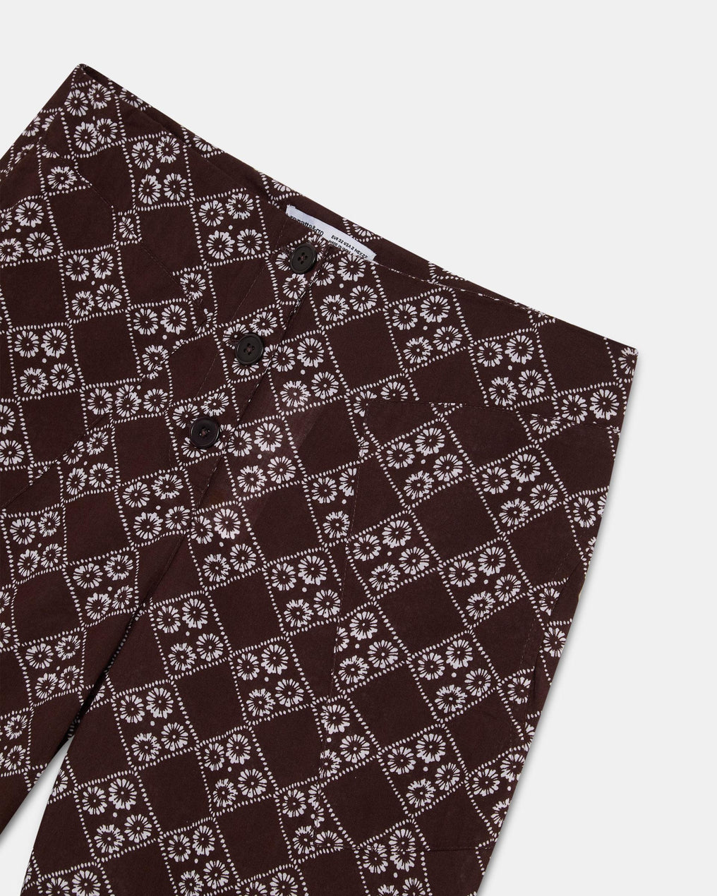 Calça fluída com estampado floral e três botões em castanho.
